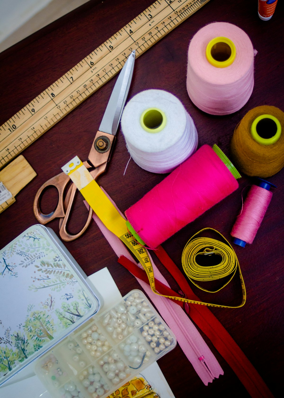 A sewing kit with threads, scissors, tape measure and zips