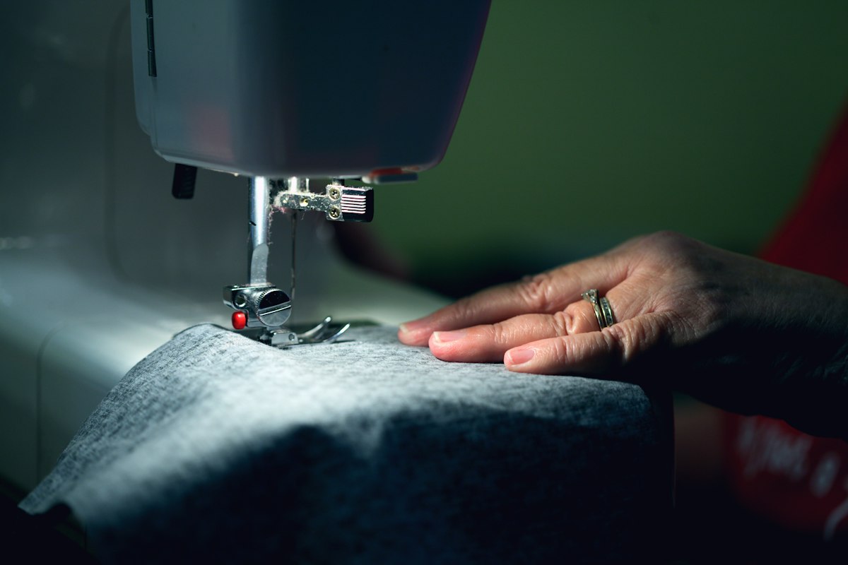 A person repairing a garment at a sewing machine