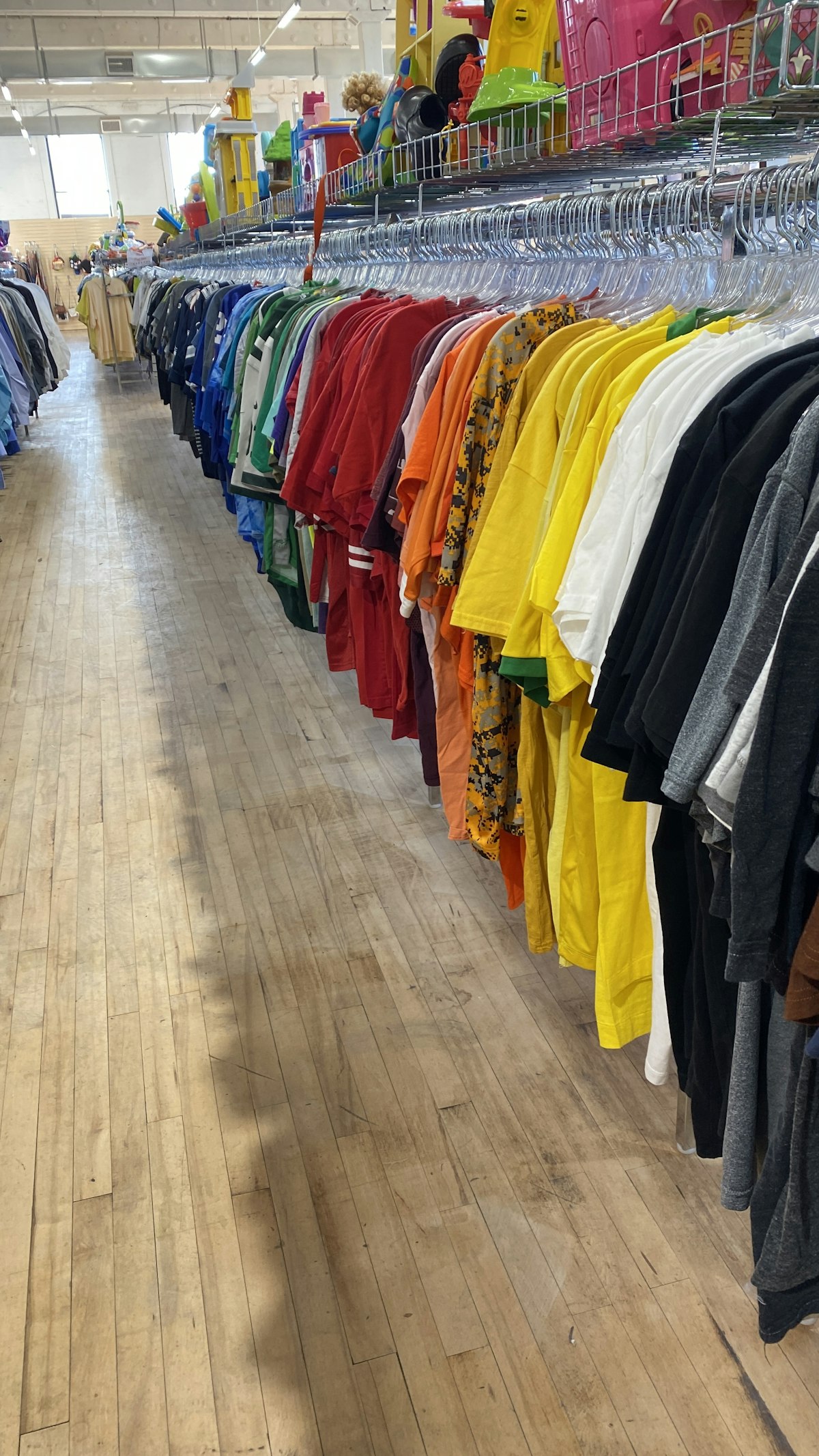 Colourful tops on a rail at a clothing swap