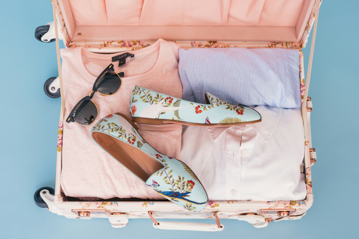 Clothing and a pair of shoes packed in a piece of luggage