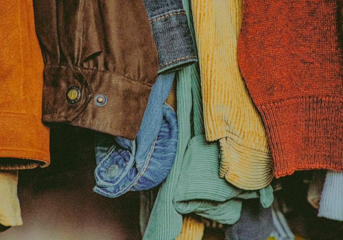 Close-up of jackets, knitwear and denim hanging together on a rail