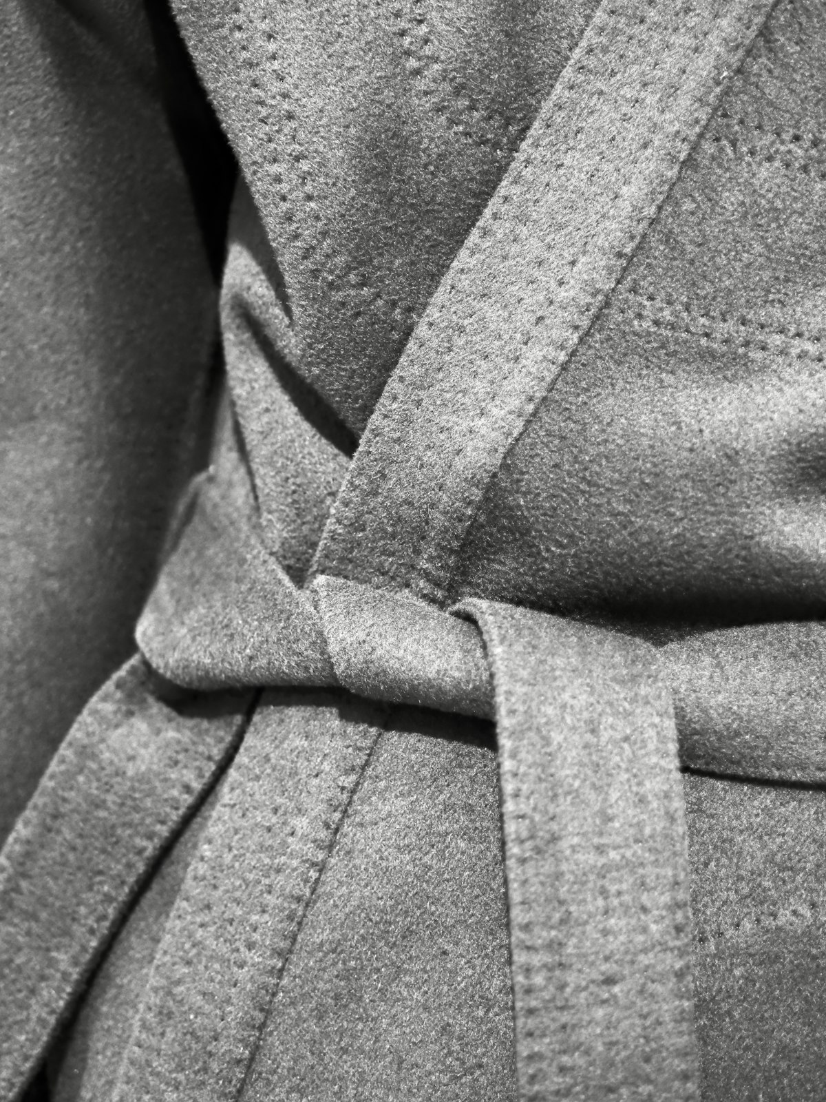 A close-up of a coat belt tied in a knot